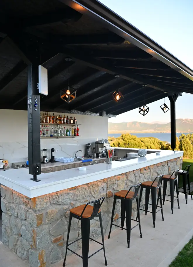 view of the stone outside bar of the hotel with a wooden roof and modern design