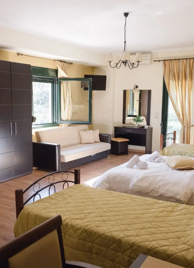inside view of the whole room of the grand family suite featuring 3 beds and furniture with golden tone colors