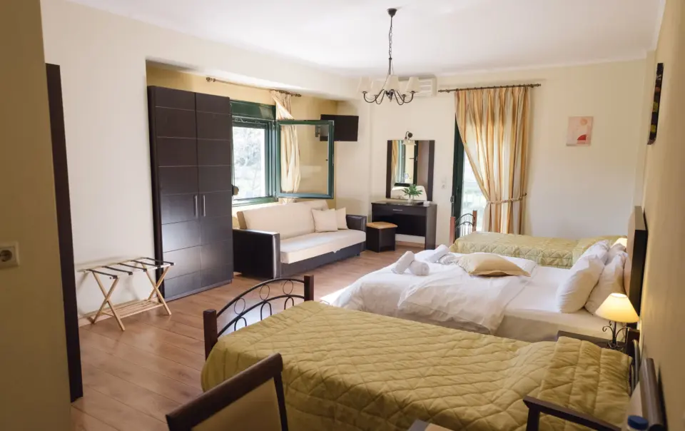 inside view of the whole room of the grand family suite featuring 3 beds and furniture with golden tone colors