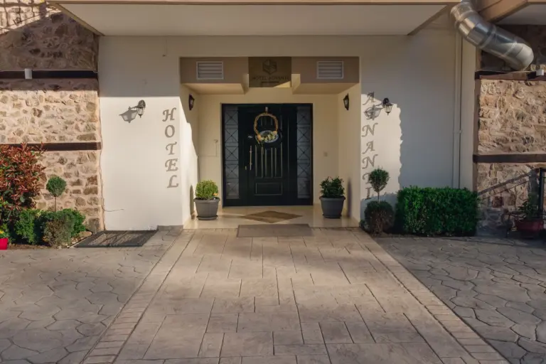 front view from the outside showcasing the main entrance of the hotel and the stone pathway to it
