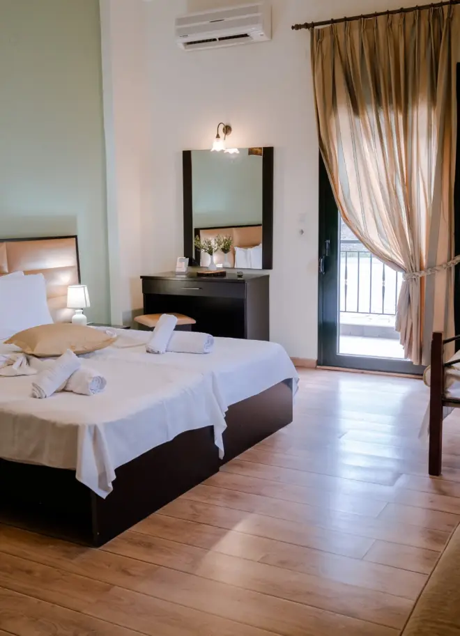 realistic photo of a hotel room featuring a large double bed with white sheets and various modern furniture around it