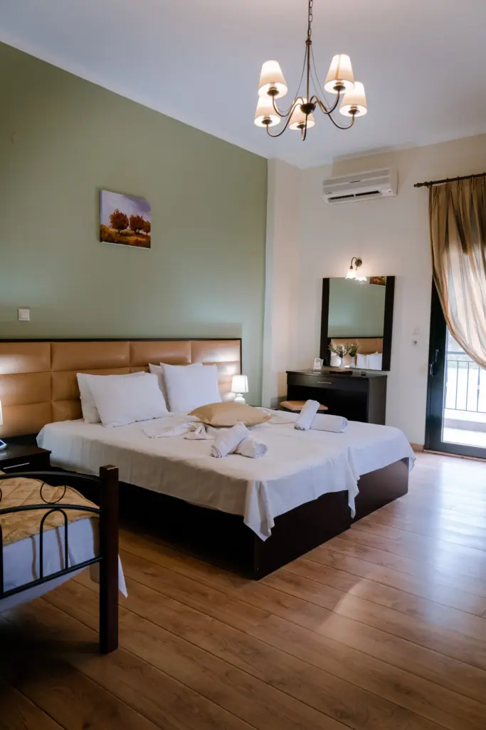 close up photo of an accessible comfort room at Hotel Agnanti Kastoria featuring a large double bed with white sheets