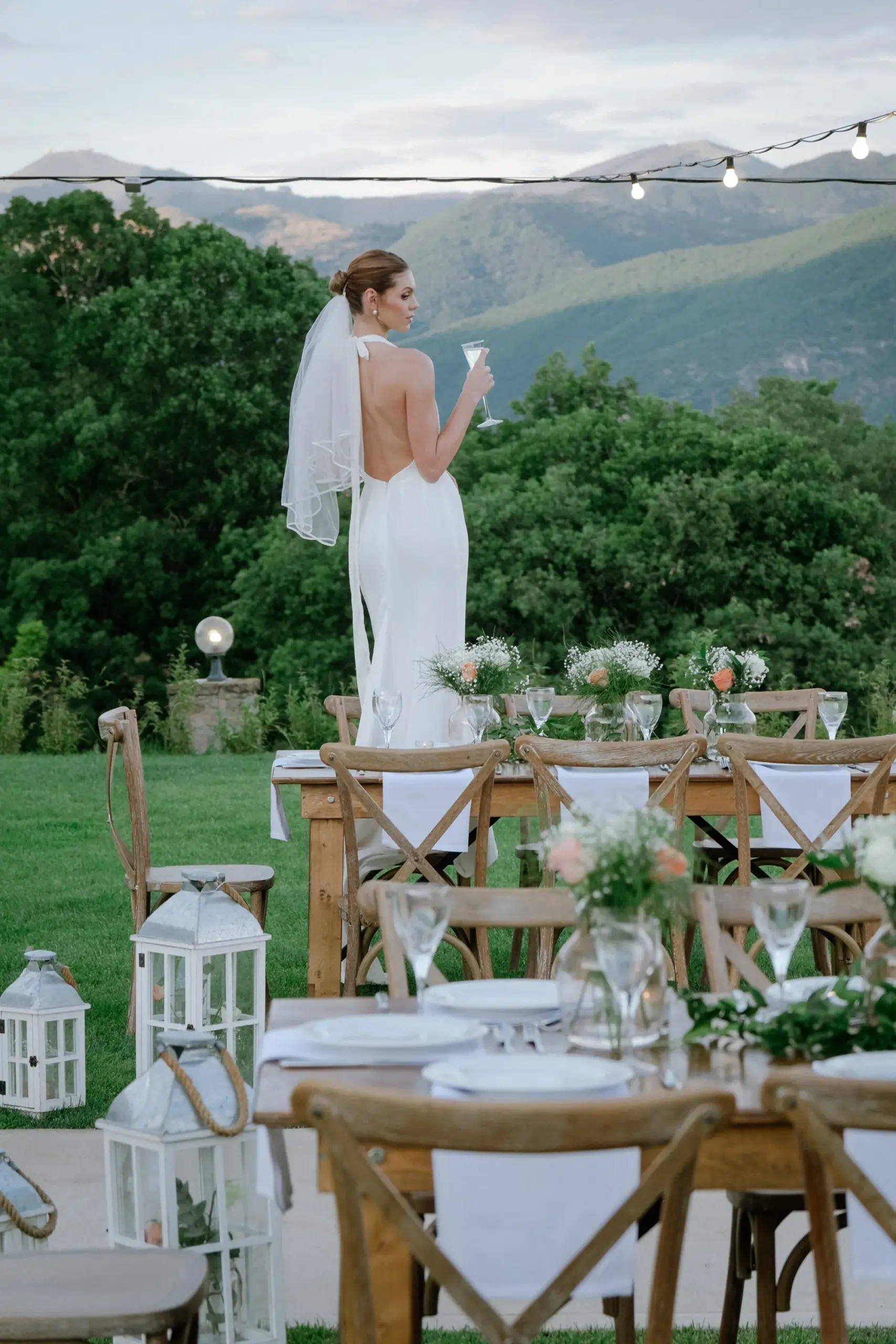 outside view of Hotel Agnanti Kastoria Wedding and Events space featuring a wedding setting with neatly decorated tables and a woman wearing a wedding dress in the background